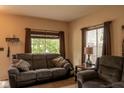 Comfortable living room featuring a gray sofa, large window with curtains, and an inviting ambiance at 6585 Dunsdin Dr, Plainfield, IN 46168