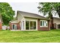 Home exterior featuring a sunroom with floor to ceiling window views and a brick patio at 6965 Steinmeier W Dr, Indianapolis, IN 46220
