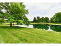 Scenic pond view with lush green landscaping surrounding the water's edge at 6965 Steinmeier W Dr, Indianapolis, IN 46220