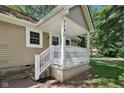 Inviting front porch featuring white railing and pillars, complemented by neutral siding and clear house number display at 7141 E Pleasant Run Pkwy S Dr, Indianapolis, IN 46219