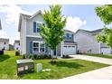 Well-maintained home with a spacious front yard, two-car garage, and charming blue shutters, providing a picturesque setting at 853 Woodbridge Way, Lebanon, IN 46052