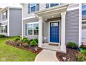 Inviting entrance with a vibrant blue door, complemented by manicured landscaping and a welcoming porch, perfect for guests at 853 Woodbridge Way, Lebanon, IN 46052