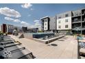 Upscale community pool with lounge chairs and tables with gray siding apartments in background at 9728 Junction, Fishers, IN 46037