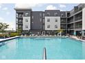 Community pool with lounge chairs and gray and white siding apartment homes in the background at 9728 Junction, Fishers, IN 46037