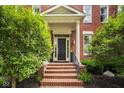 Inviting front entrance featuring brick steps, a covered porch, and manicured bushes creating a welcoming facade at 12505 Branford St, Carmel, IN 46032