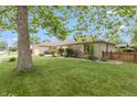 Well-maintained ranch-style house featuring a green lawn, mature trees and brick facade with an attached garage at 1415 Section St, Plainfield, IN 46168