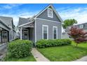 Charming gray two-story home featuring a well-maintained lawn and manicured landscaping at 1531 English Ave, Indianapolis, IN 46201