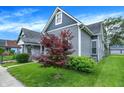 Charming gray two-story home featuring a well-maintained lawn and manicured landscaping at 1531 English Ave, Indianapolis, IN 46201