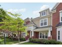 Stylish townhome featuring a brick facade, covered entrance, and landscaped front yard at 15553 Portland Dr, Westfield, IN 46074