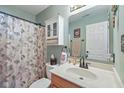 Well-lit bathroom featuring a vanity with a sink, a decorative mirror, and a shower with a floral curtain at 1896 Central Park W Blvd, Greenwood, IN 46143