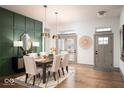 Elegant dining room with green accent wall, modern lighting, and a stylish area rug at 20005 Gansett Rd, Westfield, IN 46074