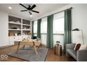 Well-lit home office with built-in shelving, a spacious desk, and comfortable seating area at 20005 Gansett Rd, Westfield, IN 46074