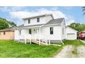 Attractive home featuring bright white siding, a covered front porch, and a well-manicured lawn at 2413 Fowler St, Anderson, IN 46012