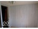 Room featuring neutral color wall panels, light fixture, and a door at 311 Fall Creek Dr, Anderson, IN 46013