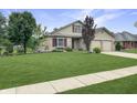 Inviting two-story home with a lush green lawn and mature trees in a well-kept neighborhood at 3287 Buckmoor Pkwy, Greenwood, IN 46143