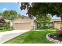 Charming single-story home boasts a manicured lawn, beautiful landscaping, and an attached garage at 392 Sandbrook Dr, Noblesville, IN 46062