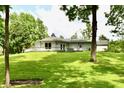 The home features a large lawn, an expansive deck and mature trees at 4115 Tansel Rd, Indianapolis, IN 46234
