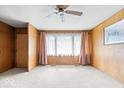 Spacious living room with neutral carpet, ceiling fan, and large windows providing ample natural light at 414 S Green St, Brownsburg, IN 46112