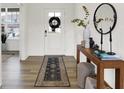 Elegant entryway featuring a stylish rug, decorative table with a mirror, and a glass-paneled front door at 4250 Blackford Rd, Bargersville, IN 46106