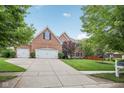 Charming brick home with an attached three car garage, well maintained lawn and mature trees at 427 Quincy Pl, Westfield, IN 46074