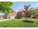 Brick home with a three car garage and an expansive, well-maintained lawn at 427 Quincy Pl, Westfield, IN 46074