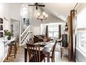 Open concept dining room with vaulted ceilings, a chandelier, and views of the staircase and living area at 4380 Dunsany Ct, Indianapolis, IN 46254