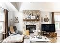 Cozy living room with a stone fireplace, comfortable seating, and a bright window for natural light at 4380 Dunsany Ct, Indianapolis, IN 46254