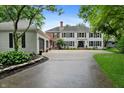 Charming two-story home with a two-car garage, a long driveway, black shutters, and mature trees surrounding the property at 4443 Mallard Pt, Columbus, IN 47201