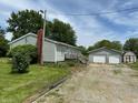 The property showcases a detached two-car garage and a quaint shed next to the main house at 4673 S 400 W, New Palestine, IN 46163