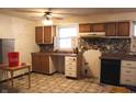 Outdated kitchen featuring wood cabinets, a laminate countertop, and patterned linoleum flooring at 515 Hawthorne Ave, Anderson, IN 46011