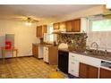 Outdated kitchen featuring wood cabinets, a laminate countertop, and patterned linoleum flooring at 515 Hawthorne Ave, Anderson, IN 46011