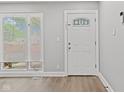 Bright entryway featuring a decorative glass door, window with blinds, and light gray walls at 5367 Penway St, Indianapolis, IN 46224