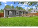 Charming gray home with a wooden porch and well-maintained lawn at 5367 Penway St, Indianapolis, IN 46224