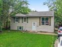 Charming two-story home featuring a well-manicured lawn and beautiful surrounding trees at 5614 Regency Dr, Indianapolis, IN 46224