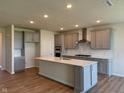 Bright kitchen boasts modern gray cabinets, stainless steel appliances, and a large center island with quartz countertop at 5673 Stetson Dr, Whitestown, IN 46052