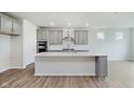 Beautiful kitchen with gray cabinets, stainless steel appliances, a center island, and hardwood floors at 5673 Stetson Dr, Whitestown, IN 46052