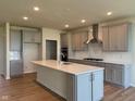 Bright kitchen boasts modern gray cabinets, stainless steel appliances, and a large center island with quartz countertop at 5673 Stetson Dr, Whitestown, IN 46052