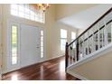 Bright foyer with hardwood floors, staircase, and a stylish light fixture at 5857 Stone Pine Trl, Carmel, IN 46033