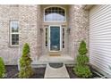 Inviting front entrance with a decorative glass door, sidelights and brick surround at 5857 Stone Pine Trl, Carmel, IN 46033