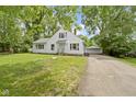 White two-story home featuring a detached garage, a well-manicured lawn, and an inviting entrance at 6833 Evanston Ave, Indianapolis, IN 46220