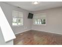 Minimalist bedroom with two windows providing natural light, complemented by neutral walls and dark floors at 6920 Wesley Ct, Indianapolis, IN 46220