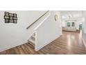 Hallway with wood-look flooring, stairs to the second floor, and a glimpse into the living room at 7834 Hillway Dr, Camby, IN 46113