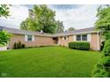Well-maintained front yard with manicured lawn and charming brick exterior at 8022 Hoover Ln, Indianapolis, IN 46260