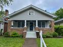 Charming home with a cozy front porch, brick accents, and a well-maintained lawn at 810 N Bosart Ave, Indianapolis, IN 46201