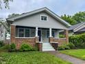 Charming home with a cozy front porch, brick accents, and a well-maintained lawn at 810 N Bosart Ave, Indianapolis, IN 46201