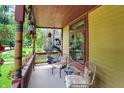 Inviting covered porch with seating, decorative lanterns, and hanging plants at 838 Woodruff Place West Dr, Indianapolis, IN 46201