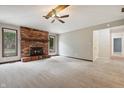 Spacious living room featuring a brick fireplace, neutral carpet, and natural light from large windows at 9189 Dawn Dr, Brownsburg, IN 46112