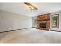 Bright living room boasts a brick fireplace, neutral carpet, and a ceiling fan for added comfort at 9189 Dawn Dr, Brownsburg, IN 46112