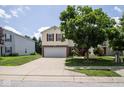 View of a two-story home with a well-maintained lawn and a large tree in the front yard at 9215 Stones Bluff Pl, Indianapolis, IN 46113