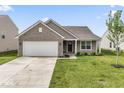 Charming single-story home featuring a two-car garage and a well-manicured lawn at 10107 Camp Creek Way, Indianapolis, IN 46229